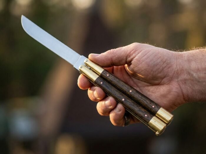 Fly balisong butterfly knife held in hand
