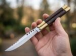 Glow Worm balisong butterfly knife held in hand