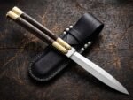 Human balisong butterfly knife shown with its leather sheath, second view
