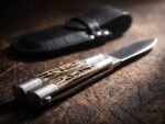 Musang Asian Palm Civet balisong butterfly knife shown with its leather sheath