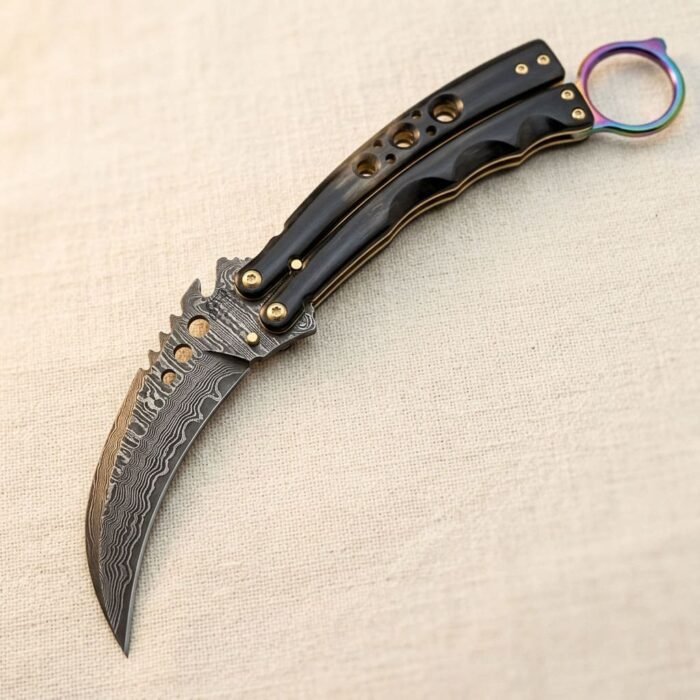 Handmade Damascus karambit balisong butterfly knife with black buffalo horn handle, brass fittings and anodised titanium ring