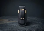 Black leather butterfly knife sheath with belt loop and brass rivets, standing upright