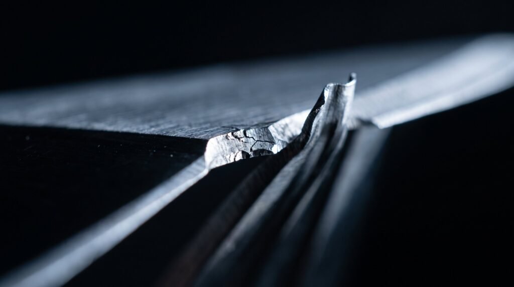 Macro of a knife cutting edge showing a chipped section beside a section that has rolled over