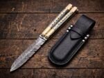 Monarch balisong butterfly knife closed beside its black leather belt sheath