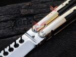 Macro view of the Mongoose balisong butterfly knife brass bolster and drilled D2 blade