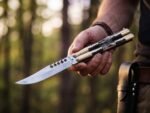 Mongoose Filipino balisong butterfly knife held open in hand, brass carabao and deer horn handle