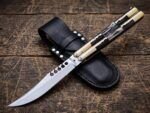 Mongoose balisong butterfly knife closed beside its black leather belt sheath
