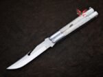 Moth balisong butterfly knife closed at an angle showing the pale bone handle scales