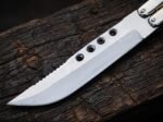 Close up of the Mule balisong butterfly knife D2 blade showing the drilled holes and serrated spine
