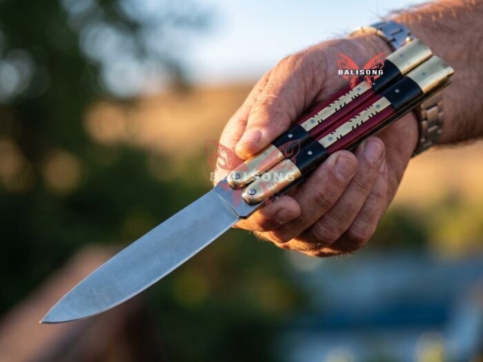 Nightingale Filipino balisong butterfly knife held open in hand, brass and micarta handle